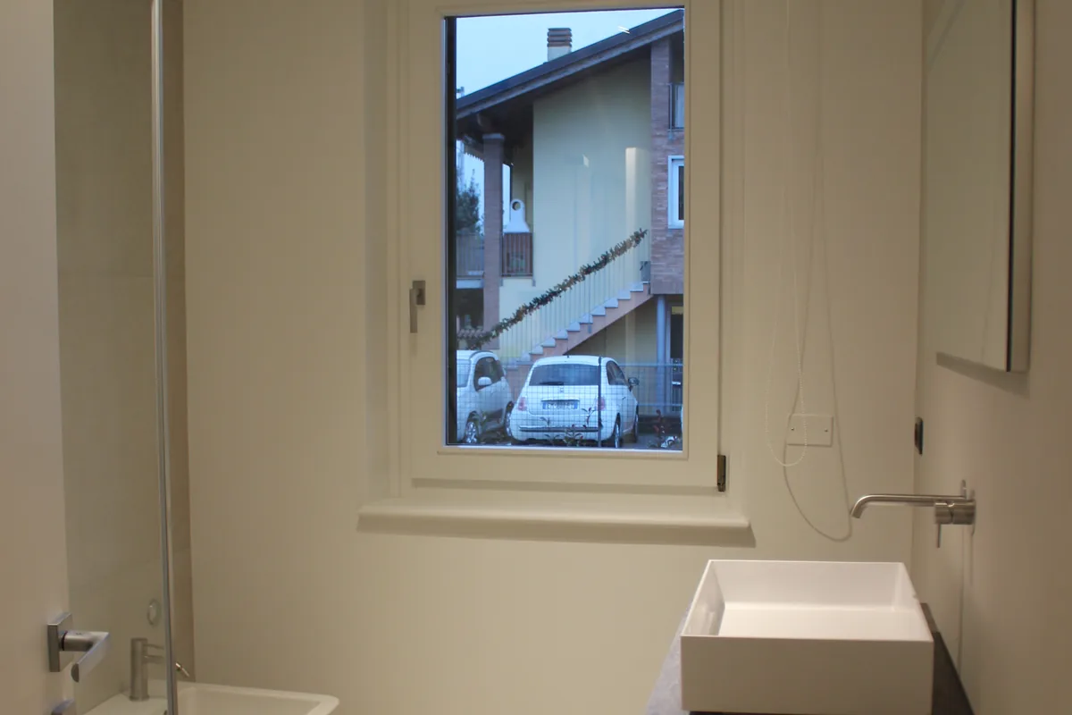 Bagno ultimato con box doccia, sanitari sospesi e mobile lavabo su misura